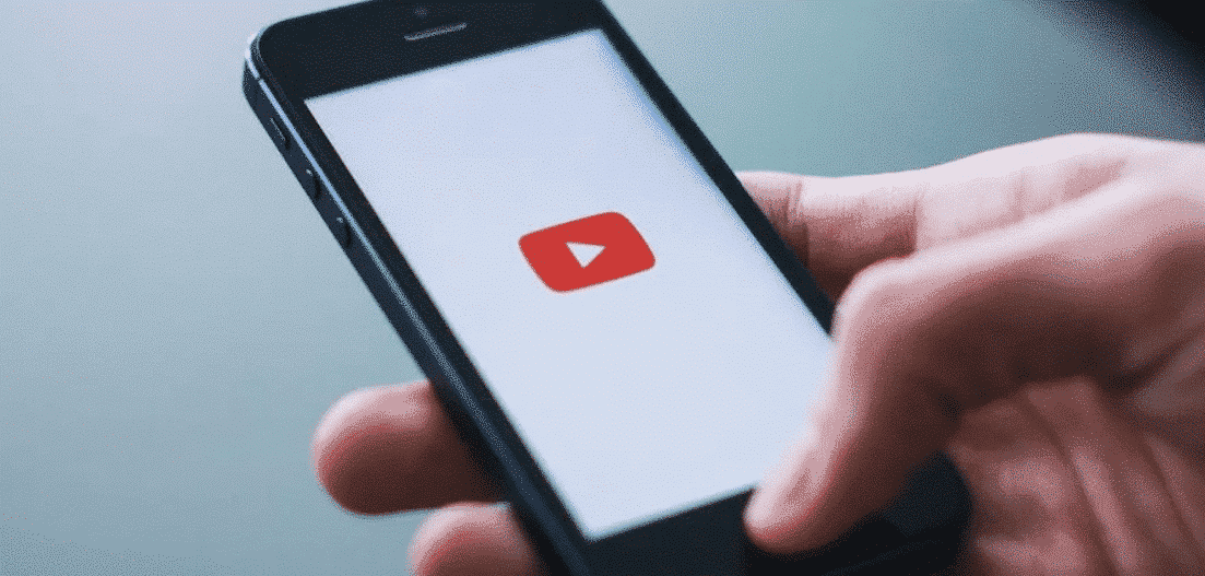 Mão com smartphone abrindo YouTube